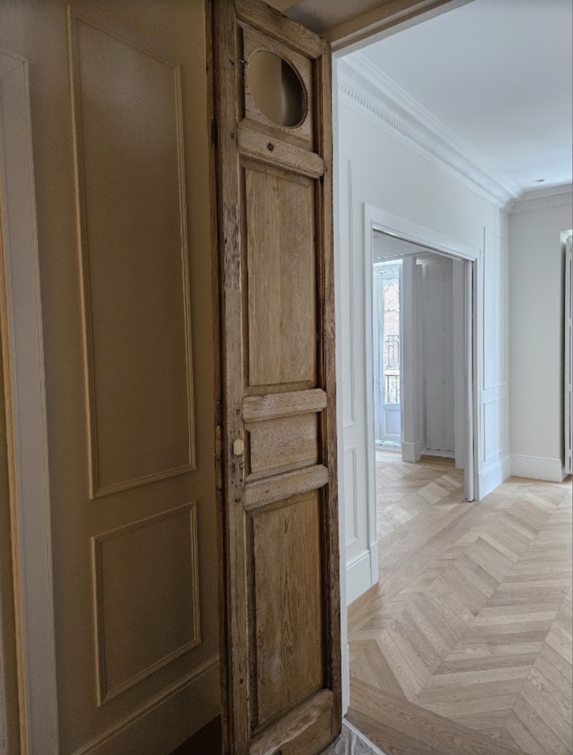 Pasillo señorial con puertas de madera y suelo de espiga