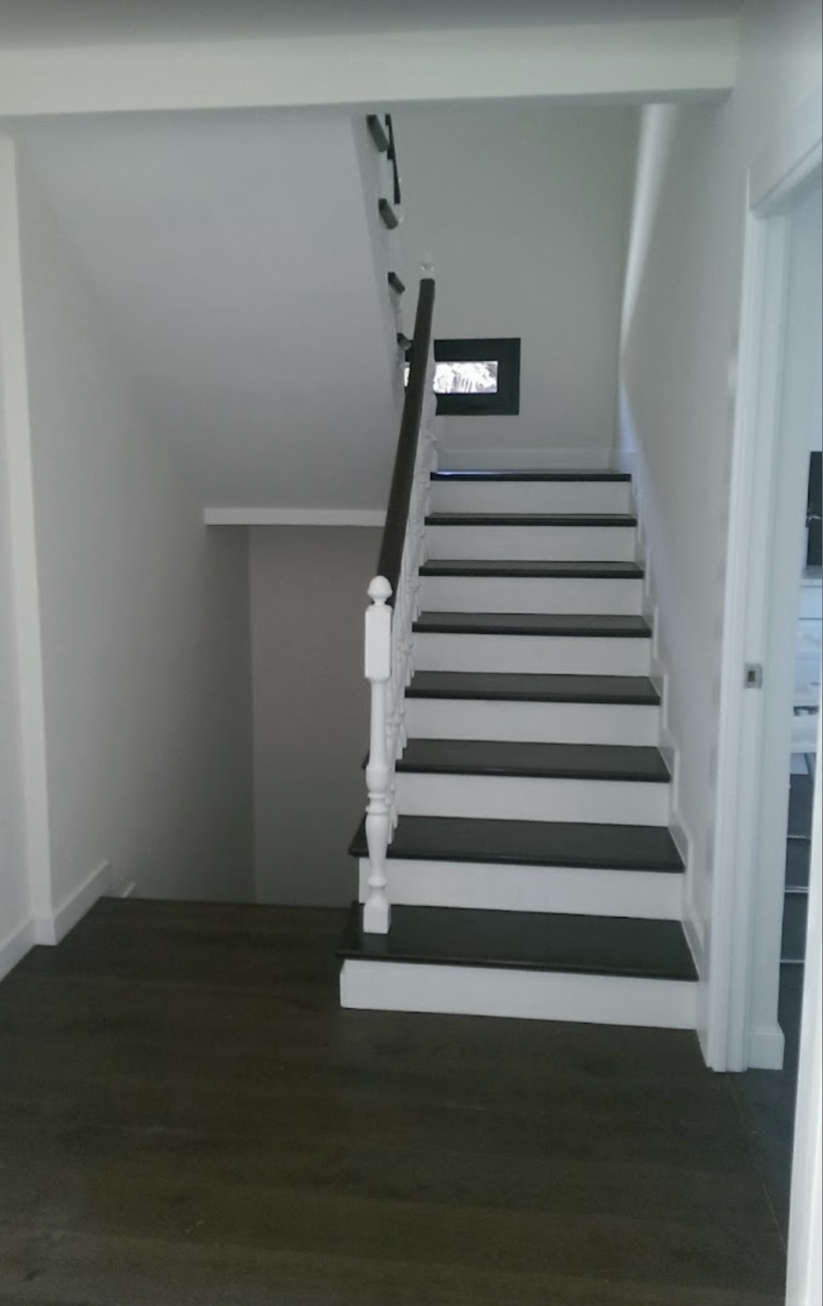 Escalera pintada en blanco y negro con suelo oscuro