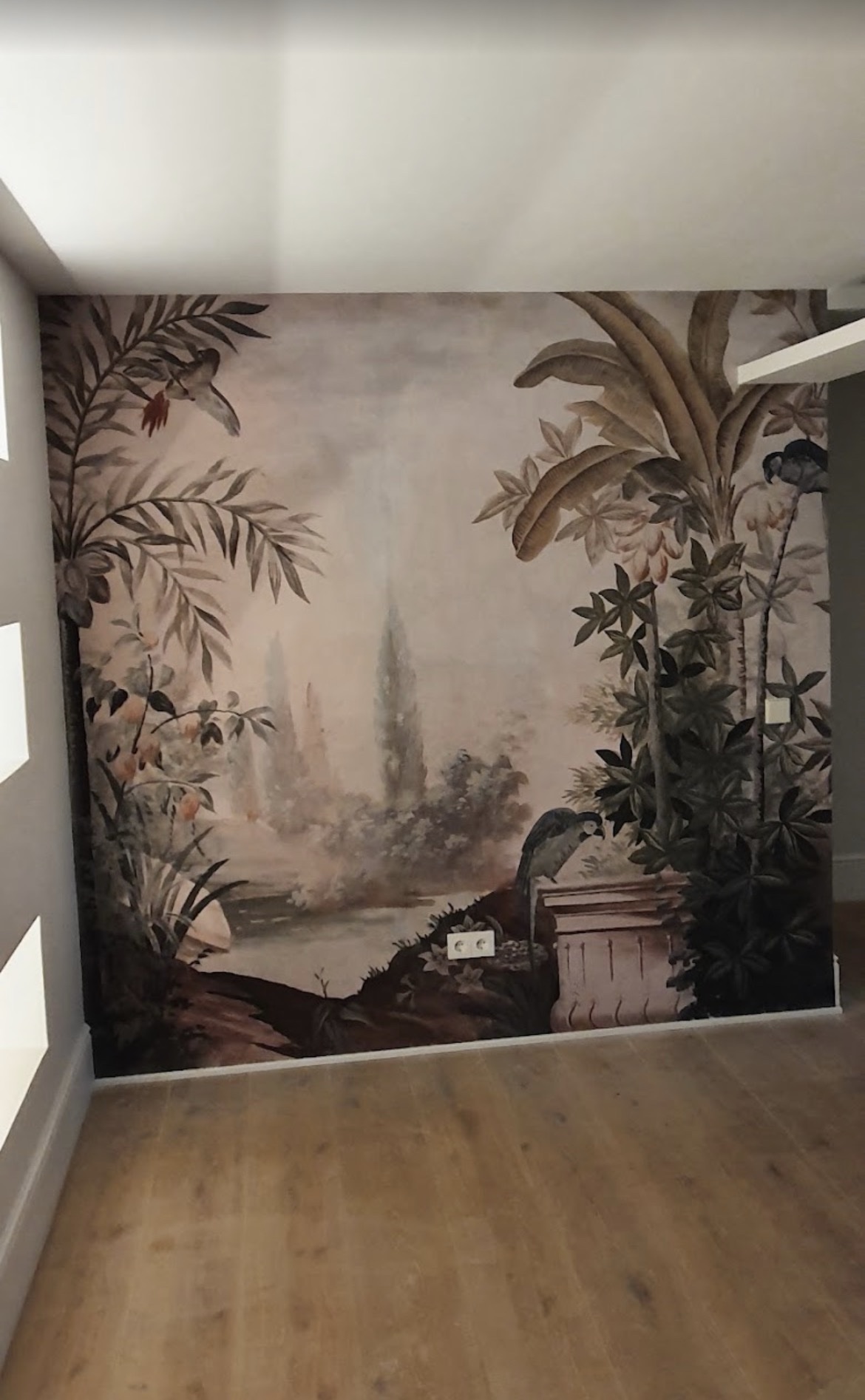 Mural pintado a mano con vegetación tropical en una habitación